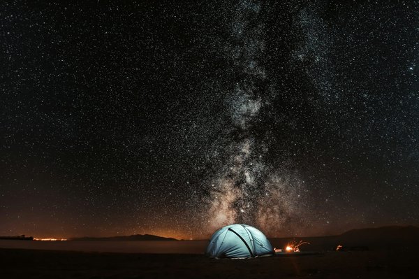 Quels sont les avantages d'utiliser une boussole traditionnelle en camping en zone non cartographiée?